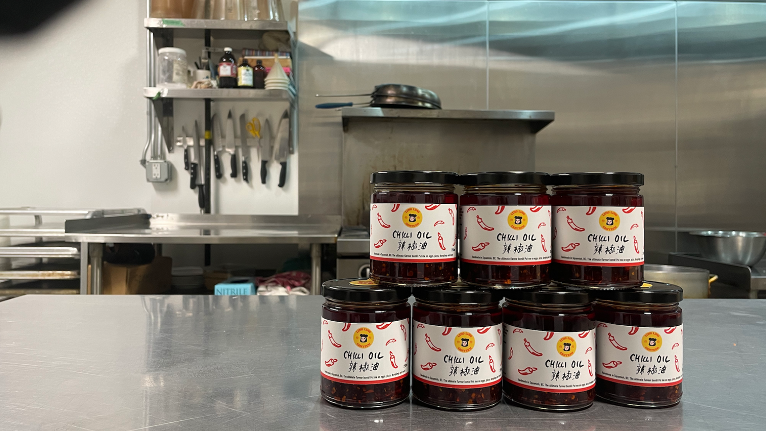Jars of Chilli Oil on a metal counter in a kitchen setting